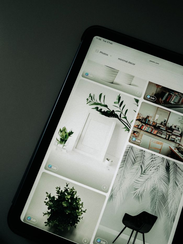 hero-img-01 Una pantalla de tableta con imágenes de decoración minimalista que resaltan la vegetación y el diseño sencillo.